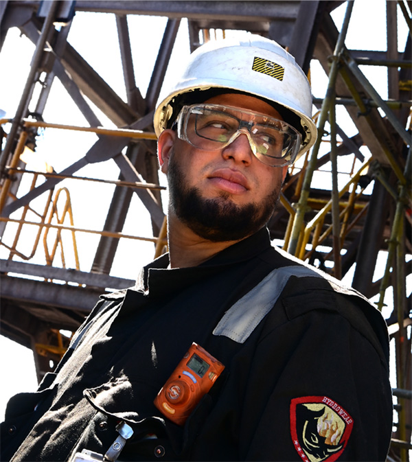 Brandwacht met helm, veiligheidsbril en gasdetector bij een staalconstructie